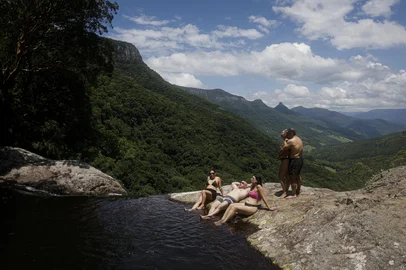 TRÊS FORQUILHAS, RS, BRASIL, 25-01-2026: A técnica em segurança do trabalho, Jaqueline Maciel (C, de rosa), 34 anos, com grupo de amigos de Osório na piscina natural com borda infinita no topo da Cascata da Pedra Branca, em Três Forquilhas, no Litoral Norte. O acesso é feito por um caminho íngreme por dentro da mata, com desnível de aproximadamente 400 metros e pouco mais de um quilômetro de extensão. Foto: Mateus Bruxel/Agência RBSIndexador: MATEUS BRUXEL<!-- NICAID(16214929) -->