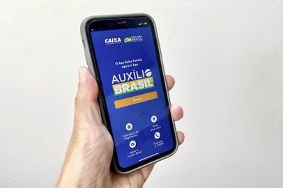 Foto de um smartphone executando o aplicativo do Auxílio Brasil.<!-- NICAID(15136275) -->