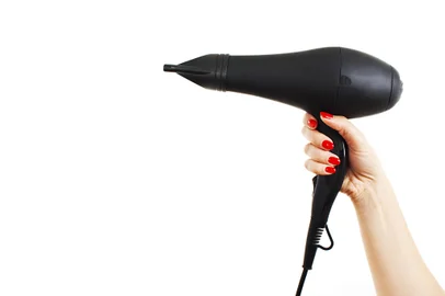 Secador de cabelo na mão sobre fundo brancoFonte: 54908184<!-- NICAID(14325162) -->