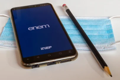 SÃ£o Paulo, Brazil - January 7, 2021: cell phone with Enem application (National High School Exam), over face protection mask and pencil with eraser. Selective focus.Fonte: 404819694<!-- NICAID(15891793) -->