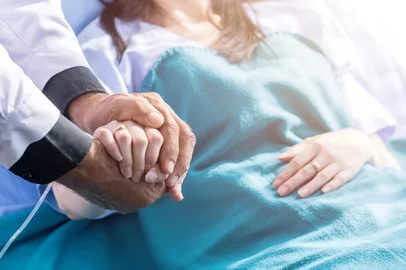 Male doctor holding female patient hand on the hospital bed. Foto:  Pitchayaarch/ stock.adobe.comFonte: 289020615<!-- NICAID(16374804) -->