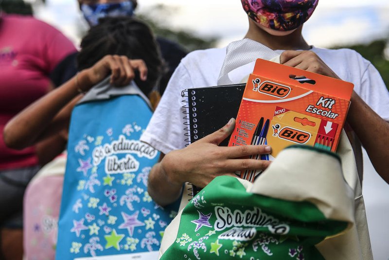 PORTO ALEGRE, RS, BRASIL,  08/03/2021- A Cooperativa de catadoras SDV Reciclando está promovendo uma ação de arrecadação e distribuição de matérias escolares para as crianças da sua comunidade. Na foto: Stefani Guedes e Paula Guedes (cabelo vermelho) e Paula Guedes (cabelo preto) entregam materiais escolares(Foto: André Ávila/Agencia RBS)Indexador: Andre Avila<!-- NICAID(14730316) -->