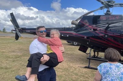 Honorata De Mari ficou ilhada na comunidade fundada por seus antepassados, no interior do município. Depois de salva, recebeu o convite para voltar a subir em um helicóptero em um dia de tempo bom.Na foto, Dona Honorata é levada passear pelo bombeiro catarinense Carlos Nataniel de Barros<!-- NICAID(15999301) -->