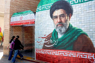 - / AFP Women walk past a banner depicting Iran's current supreme leader Ayatollah Mojtaba Khamenei along a street Tehran on May 6, 2026. The United States and Pakistan, a key mediator in the Middle East war, expressed new hope of talks leading to a peace deal with Iran on May 6, after President Donald Trump halted a plan to guide ships through the Strait of Hormuz. (Photo by AFP) / <!-- NICAID(16280572) -->