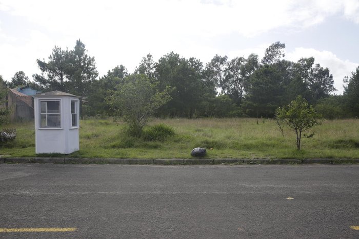 Guarida de vigilantes na frente do lote contrasta com vegetação nativa ao fundo