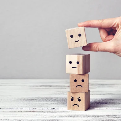 Wooden cubes with drawings of different emotions: sadness, anger, calmness, joy. Choosing joy in life  Fonte: 405499653<!-- NICAID(15942581) -->