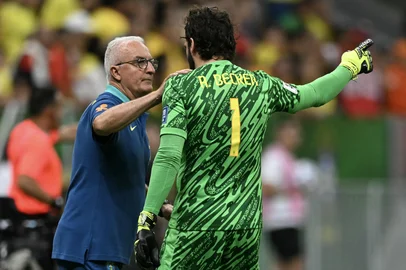 Brazil's head coach Dorival Junior speaks with Brazil's goalkeeper #01 Alisson during the 2026 FIFA World Cup South American qualifiers football match between Brazil and Colombia, at the Mane Garrincha stadium in Brasilia, on March 20, 2025. (Photo by EVARISTO SA / AFP)<!-- NICAID(16000417) -->