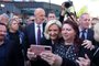 French far-right party Rassemblement National (RN) presidential candidate Marine Le Pen (C), flanked by RN member of parliament Bruno Bilde (L) and Henin-Beaumont's RN mayor Steeve Briois (R), is photographed with a mobile phone by a supporter as she leaves the polling station during the second round of France's presidential election in Henin-Beaumont, northern France, on April 24, 2022. - The French began voting on April 24, 2022 to elect their next president and choose, as in 2017, between France's President and La Republique en Marche (LREM) candidate for re-election Emmanuel Macron and France's far-right party Rassemblement National's (RN) presidential candidate Marine Le Pen. (Photo by Thomas SAMSON / AFP)<!-- NICAID(15076459) -->