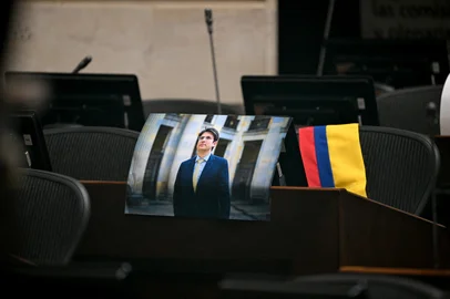 A picture of Colombian presidential candidate Miguel Uribe is displayed at his seat in Congress in Bogota on August 11, 2025. Colombian presidential candidate Miguel Uribe died two months after being shot in the head at a campaign event, his wife announced early August 11, 2025. The legislator's condition had returned to critical after he suffered a new brain hemorrhage related to the assassination attempt during a rally on June 7, in which he was shot three times, twice in the head. (Photo by Raul ARBOLEDA / AFP)<!-- NICAID(16099139) -->
