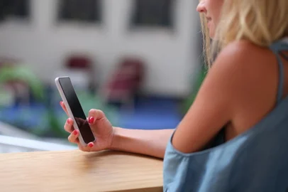 Young woman holding mobile phone in her hands and looking at screen closeupSmartphone, videos, internet. Foto: H_Ko / stock.adobe.comFonte: 724592396<!-- NICAID(15790914) -->