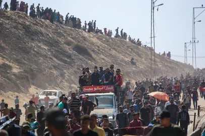 Palestinians make their way along Al-Rashid road toward Gaza City from Nuseirat in the central Gaza Strip on October 10, 2025. Israeli forces declared a ceasefire and withdrew from some positions in Gaza on October 10, as thousands of displaced Palestinians began to trek home and the families of October 7 hostages awaited news. Israeli prime minister's office said that the government had "approved the framework" of a hostage release deal with Hamas, as both sides edged closer to ending more than two years of hostilities in Gaza. (Photo by Bashar TALEB / AFP)<!-- NICAID(16143650) -->