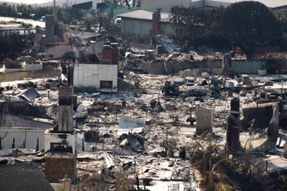 LOS ANGELES, CALIFÓRNIA - 1º DE JANEIRO: Casas queimadas pelo incêndio Palisades são vistas em 10 de janeiro de 2025 no bairro Pacific Palisades de Los Angeles, Califórnia. Vários incêndios florestais alimentados pelos ventos intensos de Santa Ana estão queimando em todo o Condado de Los Angeles. Segundo relatos, pelo menos 10 pessoas morreram. Mais de 9.000 estruturas foram danificadas ou queimadas enquanto os incêndios se espalharam para mais de 36.000 acres Apu Gomes/Getty Images/AFP (Foto de Apu Gomes / GETTY IMAGES NORTH AMERICA / Getty Images via AFP)<!-- NICAID(15951814) -->