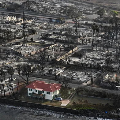 An aerial image shows a red roofed house that survived the fires surrounded by destroyed homes and buildings burned to the ground in the historic Lahaina in the aftermath of wildfires in western Maui in Lahaina, Hawaii on August 10, 2023. Embattled officials in Hawaii who have been criticized for the lack of warnings as a deadly wildfire ripped through a town insisted on August 16 that sounding emergency sirens would not have saved lives. At least 110 people died when the inferno levelled Lahaina last week on the island of Maui, with some residents not aware their town was at risk until they saw flames for themselves. (Photo by Patrick T. Fallon / AFP)Editoria: DISLocal: LahainaIndexador: PATRICK T. FALLONSecao: fireFonte: AFPFotógrafo: STF<!-- NICAID(15516989) -->