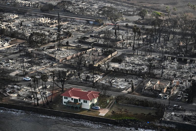 An aerial image shows a red roofed house that survived the fires surrounded by destroyed homes and buildings burned to the ground in the historic Lahaina in the aftermath of wildfires in western Maui in Lahaina, Hawaii on August 10, 2023. Embattled officials in Hawaii who have been criticized for the lack of warnings as a deadly wildfire ripped through a town insisted on August 16 that sounding emergency sirens would not have saved lives. At least 110 people died when the inferno levelled Lahaina last week on the island of Maui, with some residents not aware their town was at risk until they saw flames for themselves. (Photo by Patrick T. Fallon / AFP)Editoria: DISLocal: LahainaIndexador: PATRICK T. FALLONSecao: fireFonte: AFPFotógrafo: STF<!-- NICAID(15516989) -->