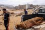 EDITORS NOTE: Graphic content / People walk past the body of a flash flood victim in the back of a pickup truck in Derna, eastern Libya, on September 11, 2023. Flash floods in eastern Libya killed more than 2,300 people in the Mediterranean coastal city of Derna alone, the emergency services of the Tripoli-based government said on September 12. (Photo by AFP)<!-- NICAID(15537971) -->