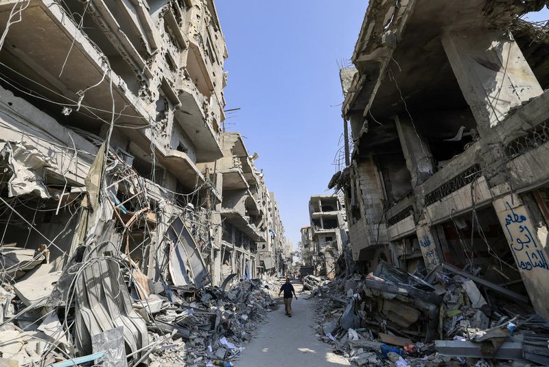A Palestinian man walks amid the rubble of buildings hit in Israeli air strikes in Khan Yunis in the southern Gaza Strip on October 24, 2023. Thousands of civilians, both Palestinians and Israelis, have died since October 7, 2023, after Palestinian Hamas militants based in the Gaza Strip entered southern Israel in an unprecedented attack triggering a war declared by Israel on Hamas with retaliatory bombings on Gaza. (Photo by MAHMUD HAMS / AFP)Editoria: WARLocal: Khan YunisIndexador: MAHMUD HAMSSecao: armed conflictFonte: AFPFotógrafo: STF<!-- NICAID(15577520) -->