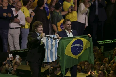 Argentina's President Javier Milei holds a national football jersey next to Brazil's right-wing presidential hopeful Flavio Bolsonaro holding a national flag during the launching of the latter's candidacy within the Liberal Party convention, in Sao Paulo, Brazil on July 25, 2026. Battered by a string of political crises, Flavio Bolsonaro launched his candidacy for Brazil's October presidential election, seeking to follow in the footsteps of his father, Jair Bolsonaro, who is serving house arrest for plotting a coup after losing the election in 2022. (Photo by Nelson ALMEIDA / AFP)Editoria: POLLocal: Sao PauloIndexador: NELSON ALMEIDASecao: diplomacyFonte: AFPFotógrafo: STF<!-- NICAID(16333962) -->
