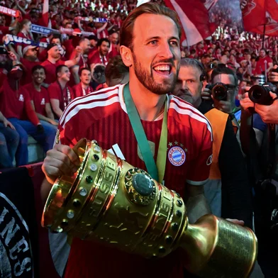 Bayern Munich's English forward #09 Harry Kane and his teammates celebrate with the trophy in front of their fans after the German Cup (DFB Pokal) final football match FC Bayern Munich v VfB Stuttgart at the Olympic Stadium in Berlin, on May 23, 2026. (Photo by Tobias SCHWARZ / AFP) / DFB REGULATIONS PROHIBIT ANY USE OF PHOTOGRAPHS AS IMAGE SEQUENCES AND QUASI-VIDEO.<!-- NICAID(16291950) -->