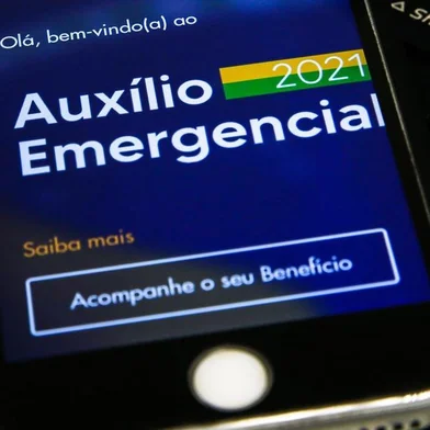 Celular com o aplicativo do axílio emergencial, benefício do governo federal durante a pandemia.<!-- NICAID(14769385) -->