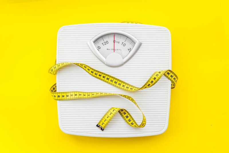 bathroom scales and measuring tape for weight loss concept on yellow background top viewBalança, fita métrica. Foto: 9dreamstudio  / stock.adobe.comFonte: 268233188<!-- NICAID(15693733) -->