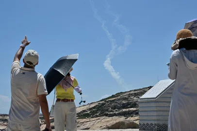 Smoke trails from projectiles launched by the Chinese military are seen as tourists look on from Pingtan island, one of mainland China's closest point from Taiwan, in Fujian province on August 4, 2022. - China's largest-ever military exercises encircling Taiwan kicked off on August 4, in a show of force straddling vital international shipping lanes after a visit to the island by US House Speaker Nancy Pelosi. (Photo by Hector RETAMAL / AFP)<!-- NICAID(15166699) -->