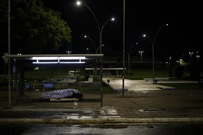 PORTO ALEGRE, RS, BRASIL, 13-06-2025: Morador em situação de rua abrigado em uma parada de ônibus em noite fria na avenida Osvaldo Aranha, em frente ao auditório Araújo Viana. Porto Alegre tem acolhimento em abrigos durante o inverno, mas nem sempre vagas dão conta de toda população que vive nas ruas. Foto: Mateus Bruxel/Agência RBSIndexador: MATEUS BRUXEL<!-- NICAID(16060345) -->