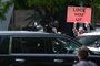 A demonstrator holds a sign as a motorcade of vehicles, with former US President Donald Trump on board, arrives at Wilkie D. Ferguson Jr. United States Federal Courthouse in Miami, Florida, on June 13, 2023. Trump is appearing in court in Miami for an arraignment regarding 37 federal charges, including violations of the Espionage Act, making false statements, and conspiracy regarding his mishandling of classified material after leaving office. (Photo by RICARDO ARDUENGO / AFP)Editoria: CLJLocal: MiamiIndexador: RICARDO ARDUENGOSecao: policeFonte: AFPFotógrafo: STR<!-- NICAID(15455005) -->
