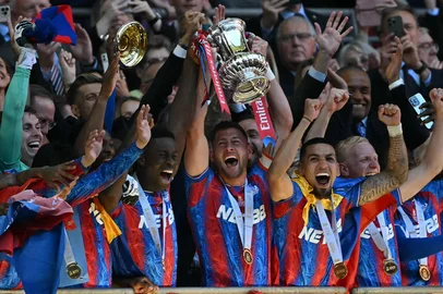 Crystal Palace's English defender #06 Marc Guehi (centre left) and Crystal Palace's English defender #02 Joel Ward (centre right) lift the trophy as Crystal Palace players celebrate after the English FA Cup final football match between Crystal Palace and Manchester City at Wembley stadium in London, on May 17, 2025. Crystal Palace beat Manchester City 1-0 in the FA Cup final at Wembley on Saturday to win the first major trophy in the club's history. (Photo by Glyn KIRK / AFP) / NOT FOR MARKETING OR ADVERTISING USE / RESTRICTED TO EDITORIAL USE<!-- NICAID(16039684) -->