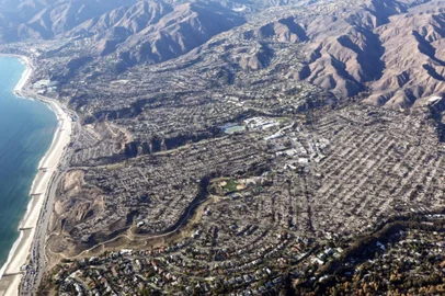 PACIFIC PALISADES, CALIFORNIA - JANUARY 13: An aerial view of homes destroyed in the Palisades Fire as wildfires cause damage and loss through the LA region on January 13, 2025 in Pacific Palisades, California. Multiple wildfires fueled by intense Santa Ana Winds continue to burn across Los Angeles County, with some containment achieved. According to reports, 24 people have died with over 180,000 people under evacuation order or warning. Over 12,000 structures have been destroyed or damaged, while more than 35,000 acres have burned.   Mario Tama/Getty Images/AFP (Photo by MARIO TAMA / GETTY IMAGES NORTH AMERICA / Getty Images via AFP)<!-- NICAID(15953654) -->