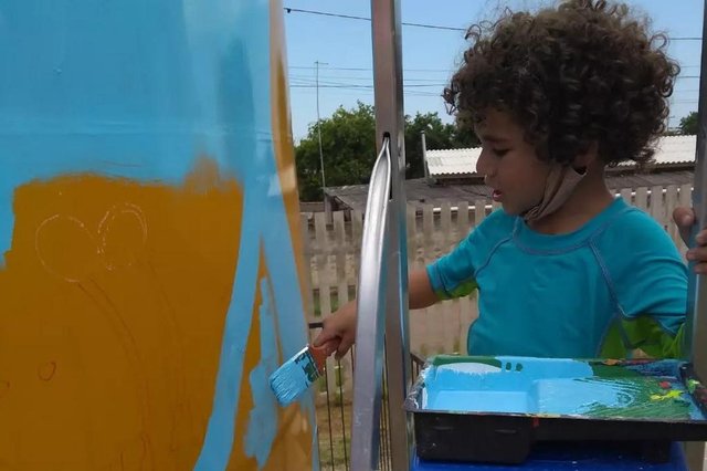 Pai e filho fazem pintura em caixa d'água da escola municipal de educação infantil Favo de Mel, em Gravataí. Na foto, Iberê Obi Lopes da Silva, de quatro anos, pintando<!-- NICAID(15018471) -->