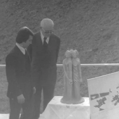 Celebração do centenário da imigração italiana em 20 de maio de 1975, em Caxias do Sul, quando o presidente Ernesto Geisel retornou à cidade.Na foto: frame da cerimônia nos fundos do Parque Cinquentenário, destacando o lançamento do monumento do centenário da imigração (que acabou não saindo), com a presença do prefeito Mário David Vanin e do presidente Ernesto Geisel. Cerimônia filmada pelo cineasta Nazareno Michelin. Filme original integra o Instituto Memória Histórica e Cultural (IMHC) da Universidade de Caxias do Sul.<!-- NICAID(16012771) -->