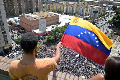 A man waves a Venezuelan flag from a balcony during a protest called by the opposition for election 'victory' to be recognised, in Caracas on August 17, 2024. Venezuela's opposition and regime supporters will vie for the streets of Caracas in competing demonstrations amid a political crisis sparked by a disputed election where both President Nicolas Maduro and his rival Edmundo Gonzalez Urrutia -backed by opposition leader Maria Corina Machado- have claimed victory. (Photo by Juan BARRETO / AFP)Editoria: POLLocal: CaracasIndexador: JUAN BARRETOSecao: governmentFonte: AFPFotógrafo: STF<!-- NICAID(15843624) -->