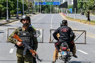 A police personnel stands guard at a closed road leading to the Serena Hotel in the Red Zone area of Islamabad on April 19, 2026. A second round of talks between the United States and Iran is expected in Islamabad this coming week. (Photo by Aamir QURESHI / AFP)<!-- NICAID(16268884) -->