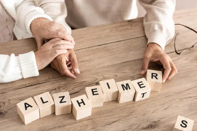 cropped view of retired couple sitting near wooden cubes with alzheimer letters.  Foto: LIGHTFIELD STUDIOS / stock.adobe.com Fonte: 303534362<!-- NICAID(16128499) -->
