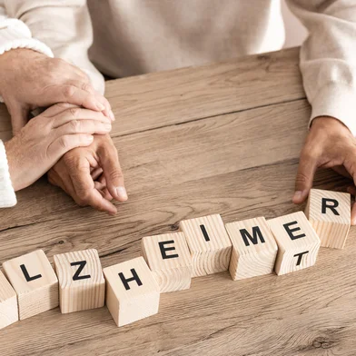 cropped view of retired couple sitting near wooden cubes with alzheimer letters.  Foto: LIGHTFIELD STUDIOS / stock.adobe.com Fonte: 303534362<!-- NICAID(16128499) -->