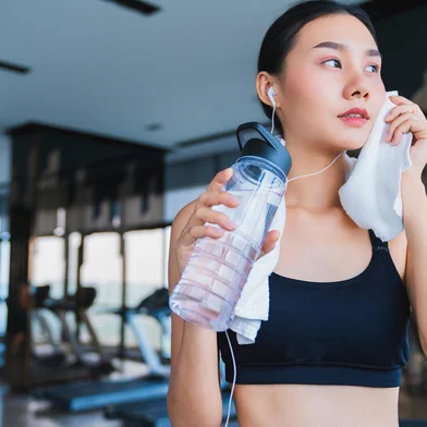 asian healthy aport woman relaxing in gym after workout hand hold pure water drink and white towelFonte: 273438127<!-- NICAID(15744852) -->
