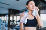 asian healthy aport woman relaxing in gym after workout hand hold pure water drink and white towelFonte: 273438127<!-- NICAID(15744852) -->