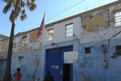 This screen grab taken from AFPTV shows people looking at the building of the main prison of Port-au-Prince, Haiti, on March 3, 2024, after a breakout by several thousand inmates. At least a dozen people died as gang members attacked the main prison in Haiti's capital, triggering a breakout by several thousand inmates, an AFP reporter and an NGO said on March 3. "We counted many prisoners' bodies," said Pierre Esperance of the National Network for Defense of Human Rights, adding that only around 100 of the National Penitentiary's estimated 3,800 inmates were still inside the facility after the gang assault overnight on March 2. (Photo by Luckenson JEAN / AFPTV / AFP)<!-- NICAID(15695878) -->