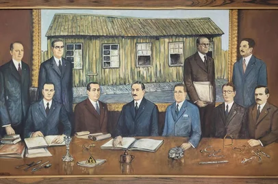 Direção da Metalúrgica Abramo Eberle retratada por Robinson Sobrera na década de 1970. Ao centro estão Abramo Eberle e os filhos José Eberle (E) e Júlio João Eberle. Nas laterais, os diretores (à esquerda) Caetano Pettinelli, Erico Raabe (de óculos) e Hugo Argenta (sentado). À direita, Oscar Martini e Pedro Moré (em pé) e Riccieri Serafini e Pedro Eberle (sentados). Quadro traz ainda, sobre a mesa, os símbolos, as marcas registradas e toda a produção da metalúrgica ao longo dos tempos. A partir da esquerda, conjunto de talheres, artigo sacro, a piteira, o triângulo (AEC), a lamparina, os motores, as facas de gaúcho e os apetrechos de selaria e montaria. Ao fundo, a casinha de madeira, réplica da primeira funilaria, fundada em 1896.<!-- NICAID(15731664) -->