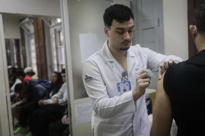 PORTO ALEGRE, RS, BRASIL, 01-06-2026: Jovem recebe vacina contra a gripe no Posto de Saúde Modelo. A partir desta segunda (01), ocorre a ampliação da vacinação contra a gripe para toda a população com mais de seis meses de idade. A medida segue orientação da Secretaria Estadual da Saúde e tem como objetivo ampliar a proteção contra a influenza, especialmente neste período de maior circulação de vírus respiratórios. Foto: Mateus Bruxel/Agência RBSIndexador: MATEUS BRUXEL<!-- NICAID(16297487) -->
