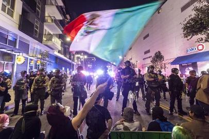 Demonstrators waving a Mexico flag, confront Police officers in riot gear during a demonstration following federal immigration operations in Los Angeles on June 9, 2025. President Donald Trump's istration said on June 9 that it was sending 700 US Marines and thousands more National Guard troops to Los Angeles, sparking a furious response from California's governor over the "deranged" deployment. Protests in Los Angeles, home to a large Latino population, broke out on June 6, triggered by immigration raids that resulted in dozens of arrests of what authorities say are illegal migrants and gang . (Photo by RINGO CHIU / AFP)<!-- NICAID(16056769) -->