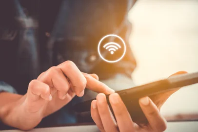 Woman hand using smartphone with wifi icon in cafe shop background. Business communication social network concept. Fonte: 222570990<!-- NICAID(15779963) -->