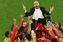 Morocco's players throw Morocco's coach Walid Regragui in the air as they celebrate at the end of the Qatar 2022 World Cup round of 16 football match between Morocco and Spain at the Education City Stadium in Al-Rayyan, west of Doha on December 6, 2022. (Photo by Glyn KIRK / AFP)<!-- NICAID(15294186) -->
