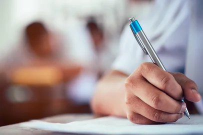 Hand of students taking exam with stress in classroom.16:9 styleIndexador: Kroo KempFonte: 264920988<!-- NICAID(15307142) -->