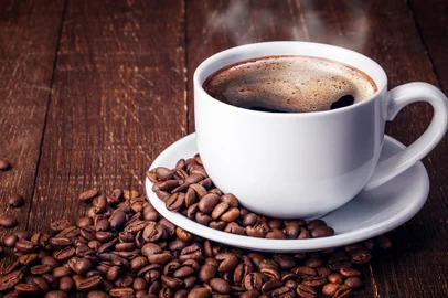 Xícara de café preto. Grãos de café ao redor<!-- NICAID(15186177) -->
