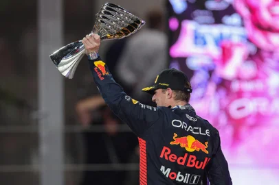 Red Bull Racing's Dutch driver Max Verstappen celebrates on the podium with the trophy  after winning the Abu Dhabi Formula One Grand Prix at the Yas Marina Circuit in the Emirati city on November 26, 2023. (Photo by Giuseppe CACACE / AFP)Editoria: SPOLocal: Abu DhabiIndexador: GIUSEPPE CACACESecao: motor racingFonte: AFPFotógrafo: STF<!-- NICAID(15638180) -->