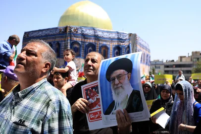 An Iranian carries a portrait of Iran's Supreme Leader Ayatollah Ali Khamenei as he stands next to a replica of the Dome of the Rock mosque during an anti-Israeli rally in Tehran on June 20, 2025. Israel and Iran exchanged fire again on June 20, a week into the war between the longtime enemies. (Photo by AFP)<!-- NICAID(16064175) -->