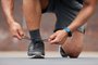 Person hands, sports and tie shoes for running workout, training and action performance on ground outdoor. Closeup of athlete, runner or lace sneakers for exercise, marathon or prepare cardio fitnessPerson hands, sports and tie shoes for running workout, training and action performance on ground outdoor. Closeup of athlete, runner or lace sneakers for exercise, marathon or prepare cardio fitness.Indexador: Yuri Arcurs peopleimages.comFonte: 629097916<!-- NICAID(15496236) -->
