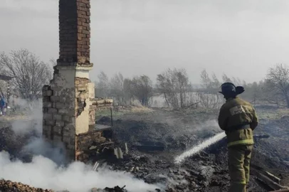 A firefighter works to extinguish a fire in the settlement of Bely Yar in the Krasnoyarsk region on May 7, 2022. - Several fires have broken out in southern Siberia, affecting about 200 buildings and causing at least five deaths, local authorities said on May 7, adding they had placed the area under a state of emergency. (Photo by Handout / Russian Emergencies Ministry / AFP) / RESTRICTED TO EDITORIAL USE - MANDATORY CREDIT "AFP PHOTO / Russian Emergencies Ministry / handout" - NO MARKETING NO ADVERTISING CAMPAIGNS - DISTRIBUTED AS A SERVICE TO CLIENTS<!-- NICAID(15089885) -->