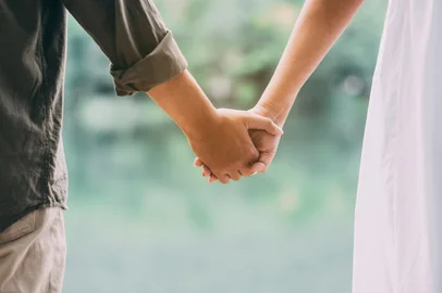 close-up of a young couple holding hands in nature<!-- NICAID(16217130) -->